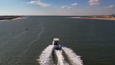 una vista aérea detrás de un barco de pesca que se dirige al mar