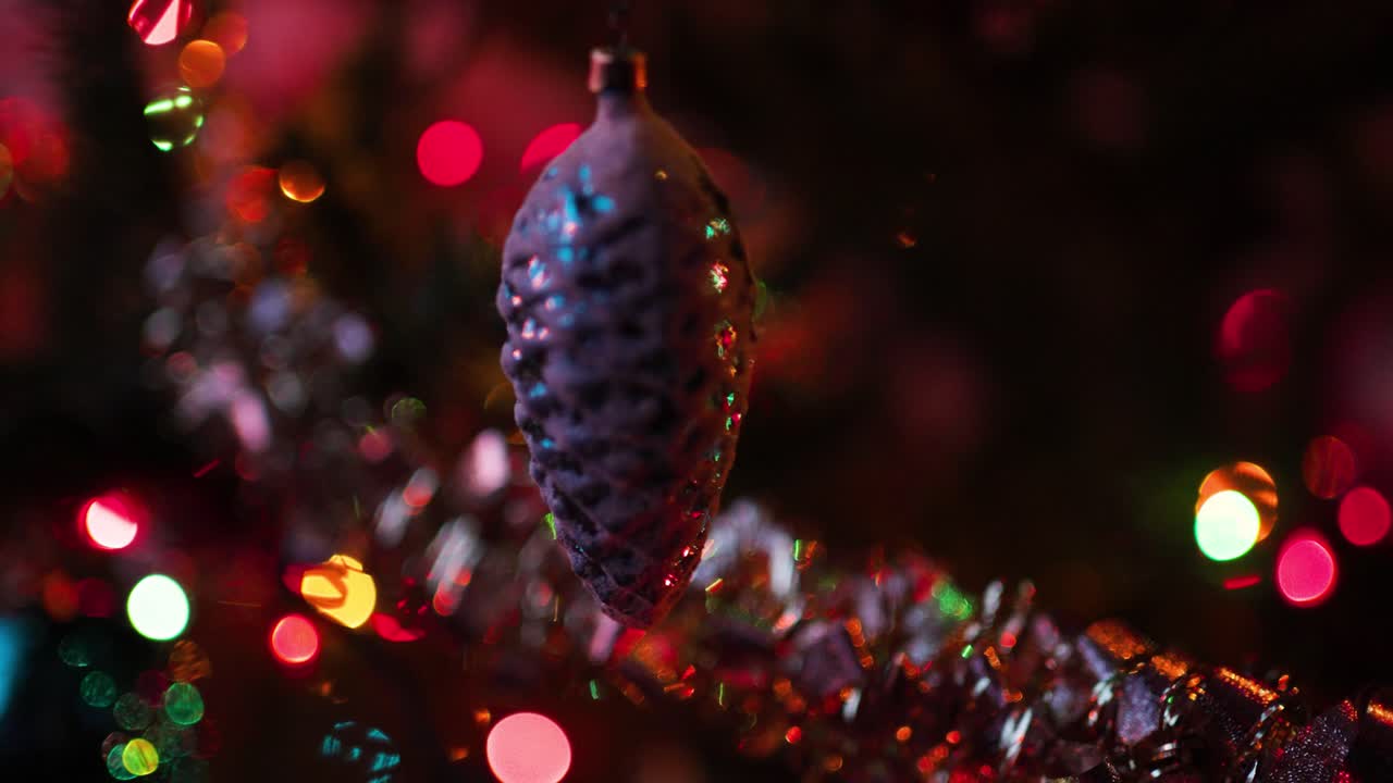 Pine cone ornament as Christmas Tree Ornament hanging with lights around it.