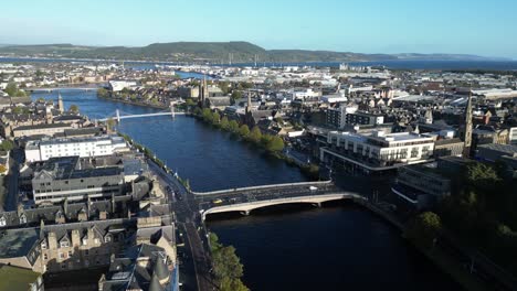 aerial drone footage of pedestrian bridges and the old town along ness river in inverness, scotland in the highlands