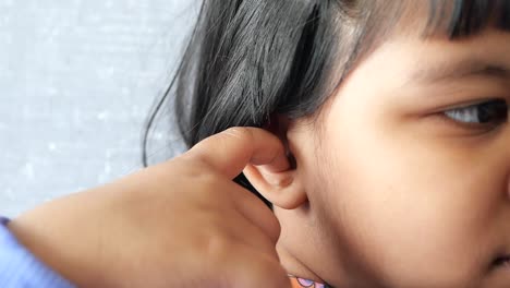 child touching her ear