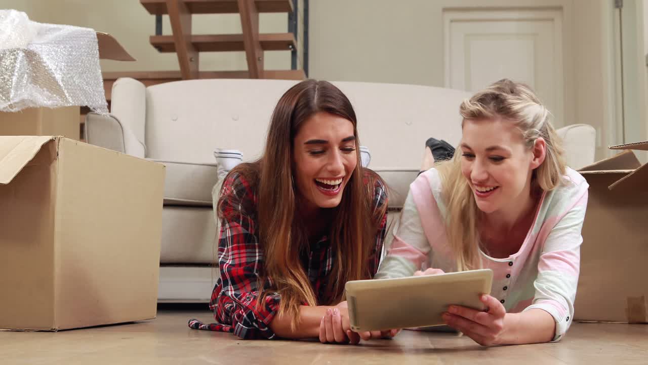 mujeres sonrientes usando una tableta