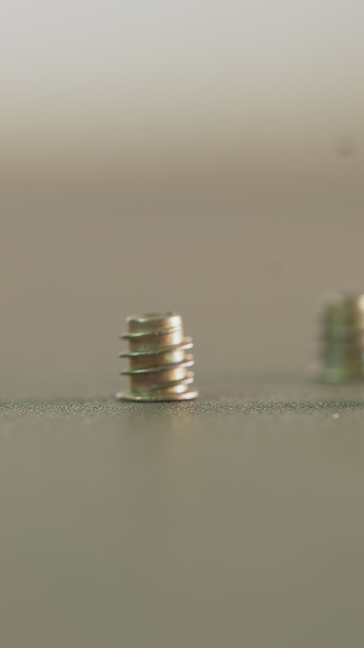 Man hand takes short screw from table surface closeup. Worker prepares fixture parts at construction site. Metal fastening for details connection