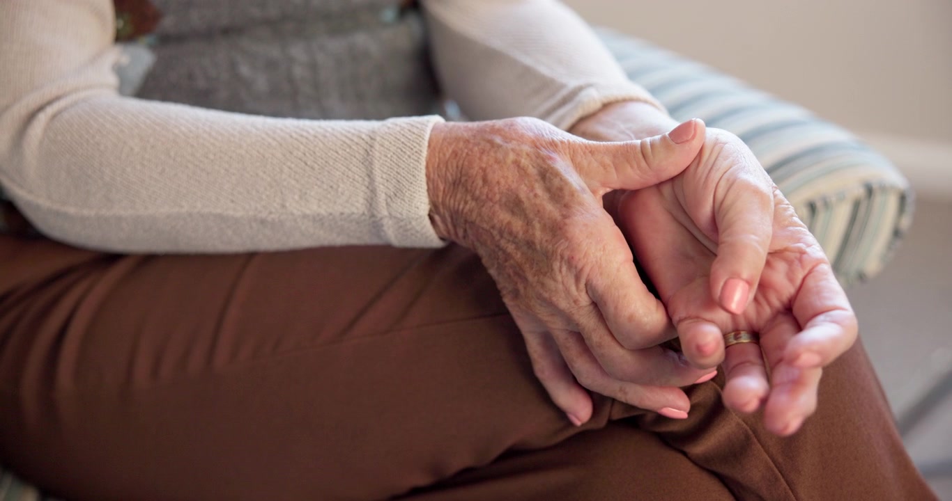 Primo piano di donna anziana con le mani appoggiate in grembo