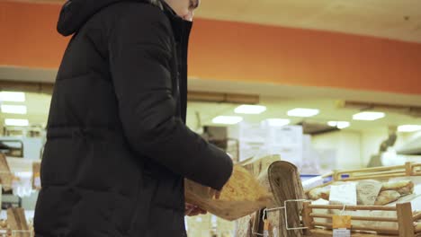 mujer joven y hombre de compras en la tienda de comestibles eligiendo pan