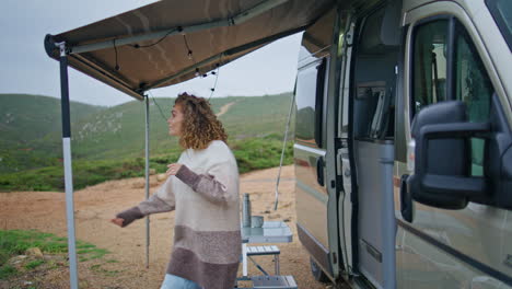 woman going out trailer to terrace with rest place. curly lady check raining