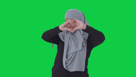 happy muslim woman showing heart sign green screen