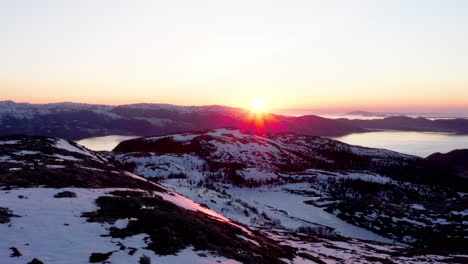 puesta de sol en las montañas nevadas y el lago con rayos de sol en blaheia, noruega