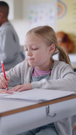 young school girl drawing in a classroom