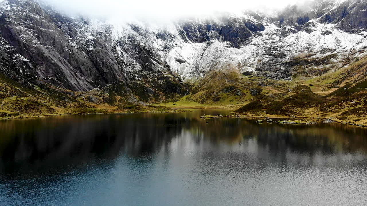 Drone footage of rock formation in Cwm Idwal, a beautiful lake in National Park, North Wales on a very windy day