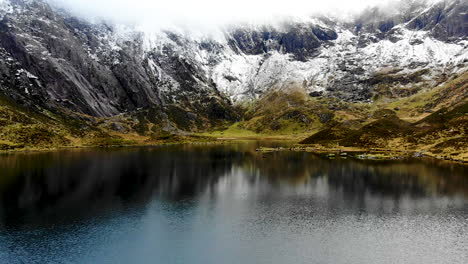 drone footage of rock formation in cwm idwal, a beautiful lake in national park, north wales on a very windy day