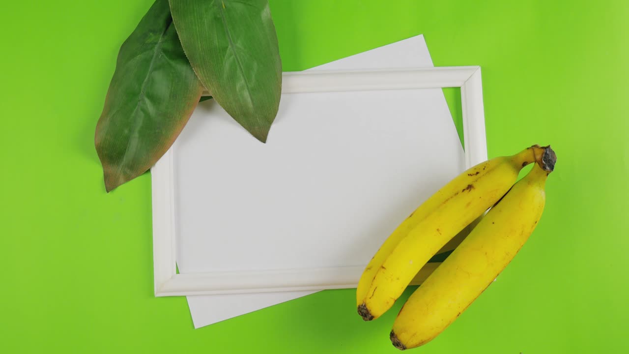 en verano. fondo floral de verano. plátanos y hojas verdes en papel blanco para el texto. vista desde arriba. 4k