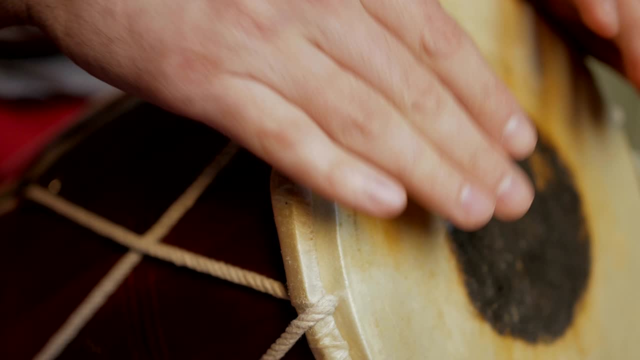 드럼을 연주하는 남자의 손을 가까이 들고 있습니다.