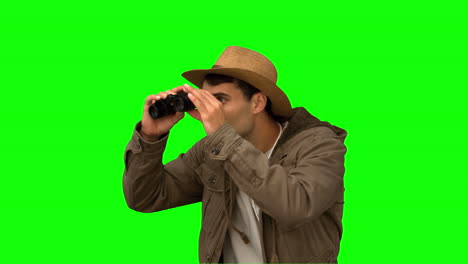 Man-wearing-a-coat-using-binoculars-on-green-screen