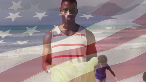 animation of flag of united states of america over happy african american father and son on beach