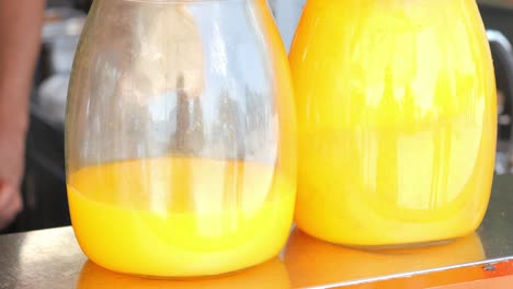 orange juice in large glass jugs