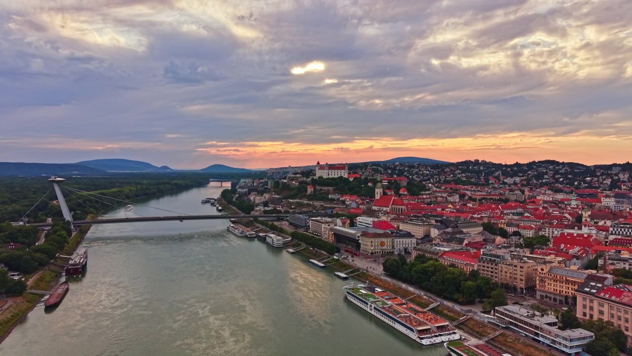Vue du ciel de Bratislava au coucher du soleil avec des ponts et des bâtiments le long du fleuve Danube