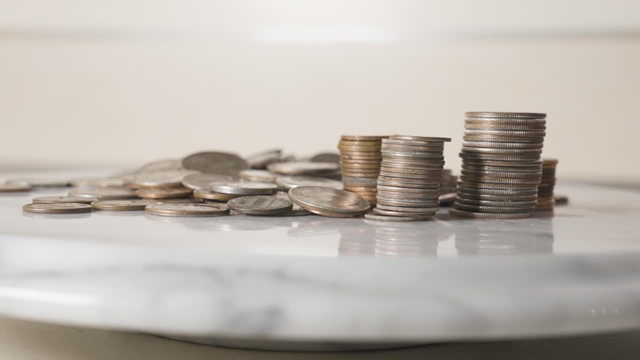 Moedas de um e vinte e cinco centavos empilhadas em um prato.