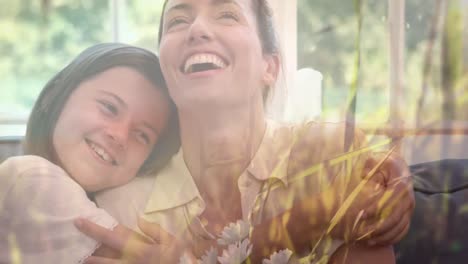 animation of grass in sun over happy caucasian mother with daughter cuddling