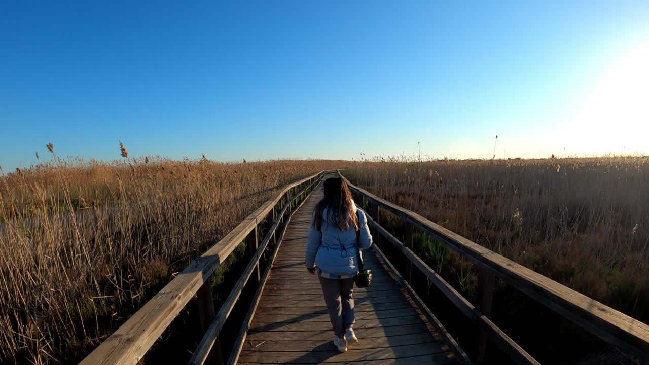 Woman walking through a wildlife preserve on a cool autumn day