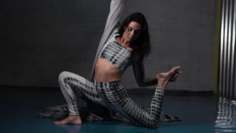 Brunette-woman-warming-up-before-doing-dancing-exercises-in-a-gym,-fit-hobby-concept