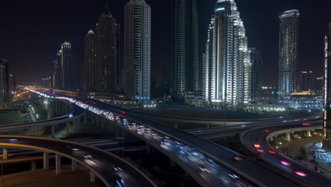 night cityscape with illuminated skyscrapers and dynamic highway traffic