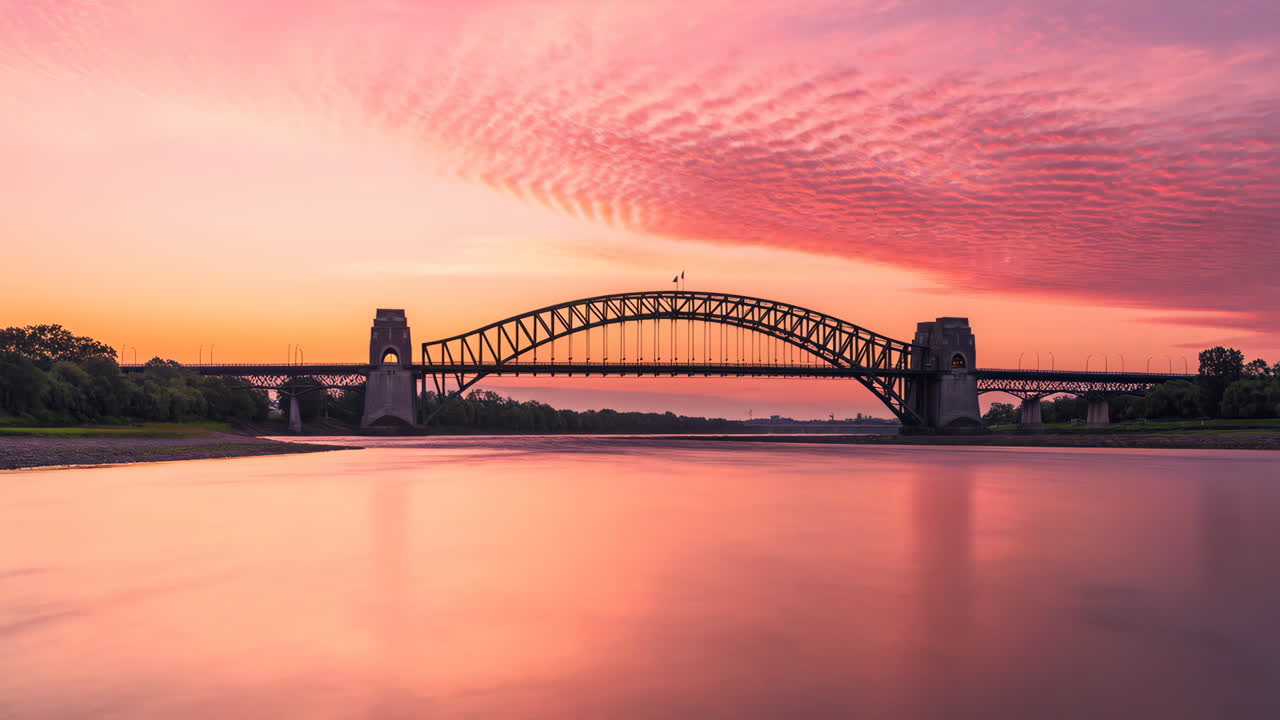 Vibrant Sunset Over a Large Arch Bridge