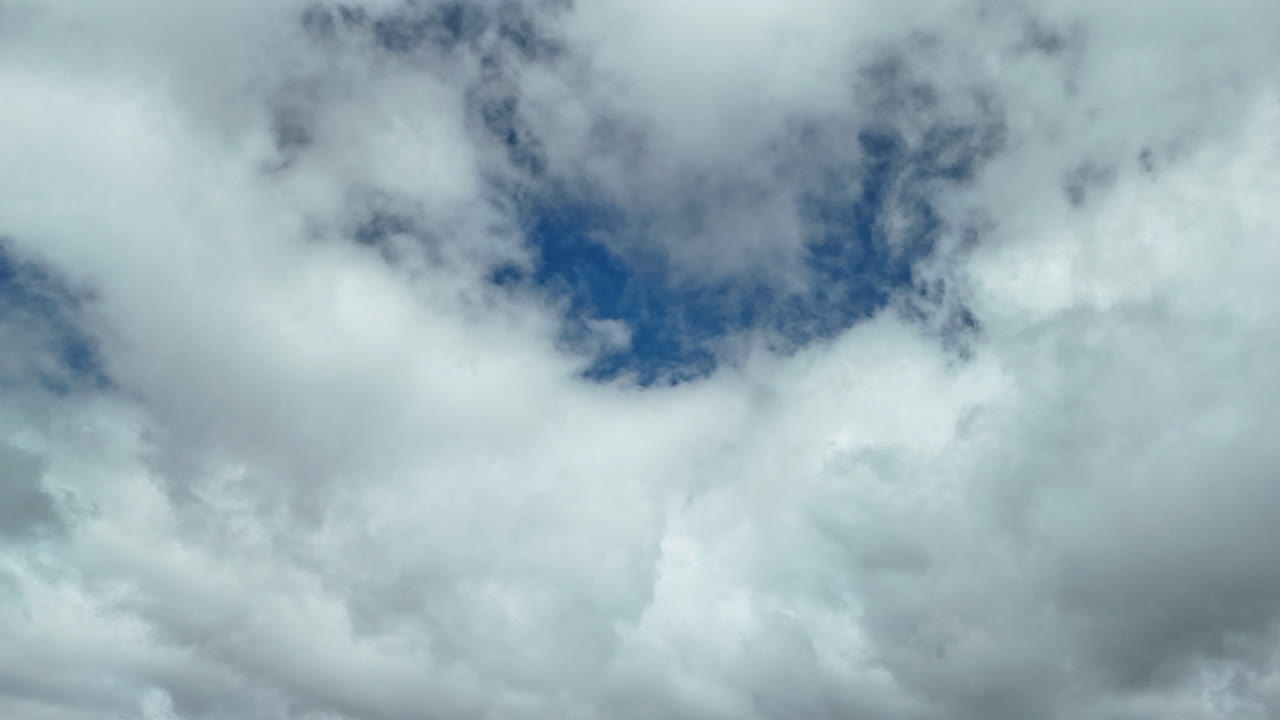 Dynamic timelapse of fluffy white clouds drifting over a bright blue morning sky in late monsoon