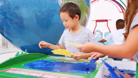 Un-Par-De-Niños-Jóvenes-Haciendo-Un-Rompecabezas-De-Mapas-En-El-Centro-De-Ciencias