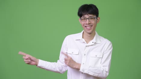 young asian businessman smiling while pointing to the side