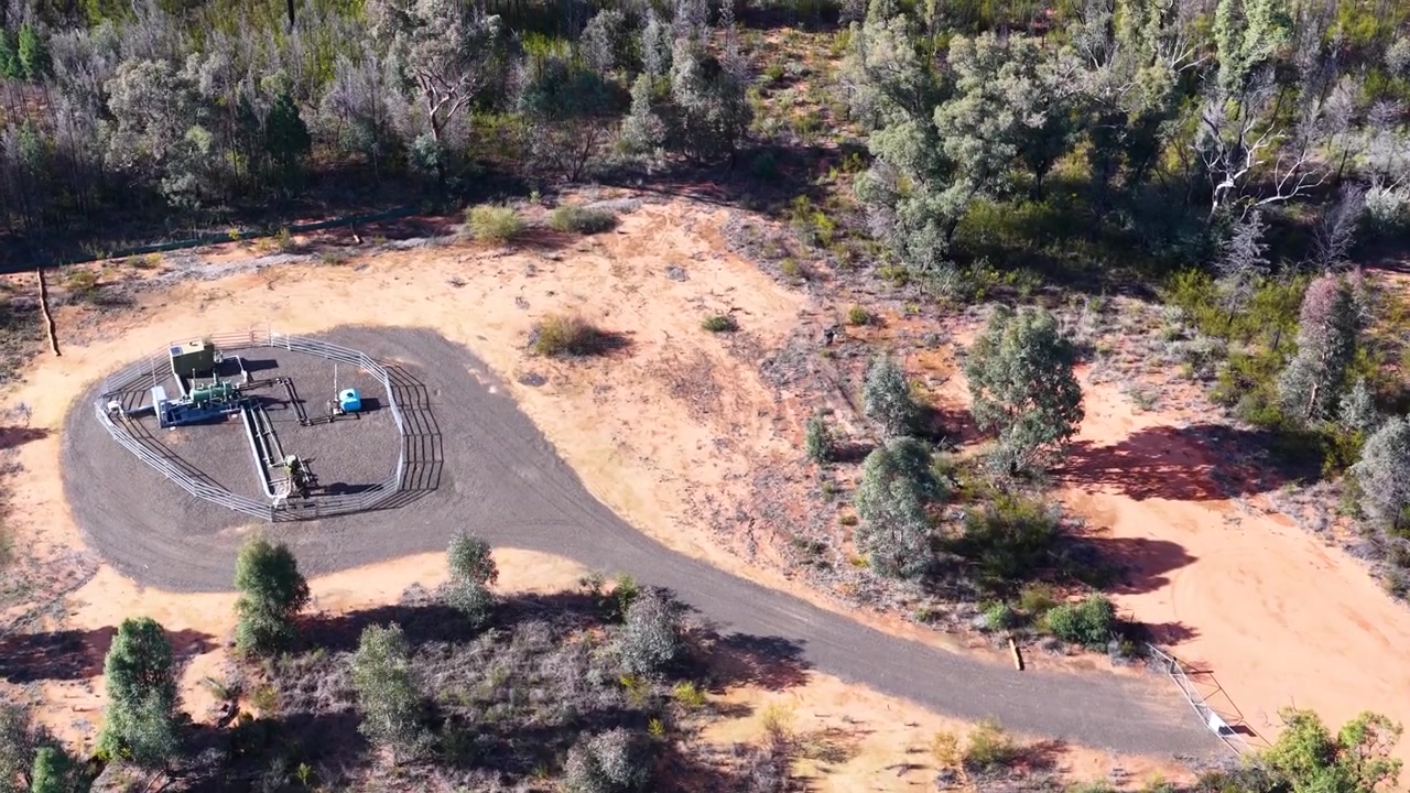 Aerial view flying over a natural gas extraction well in the Australian bushland.