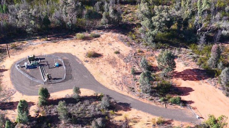 Aerial view flying over a natural gas extraction well in the Australian bushland.