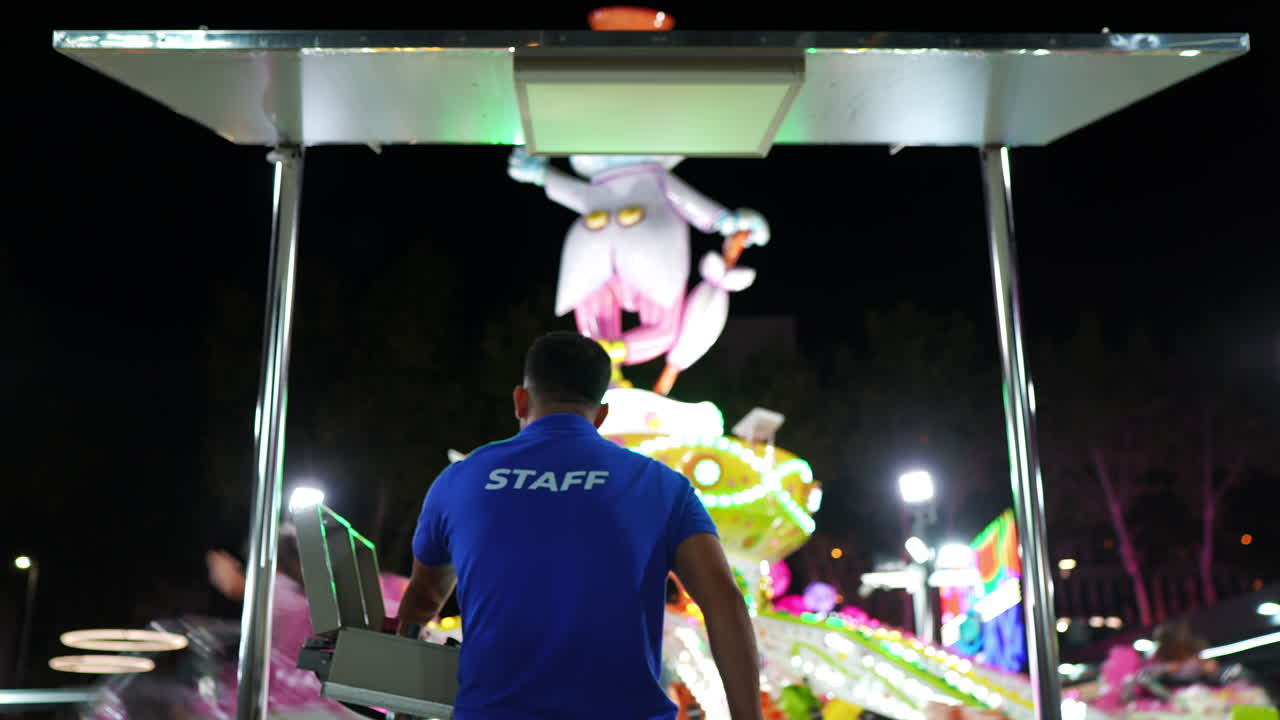 Amusement Park Staff Operating a Ride at Night