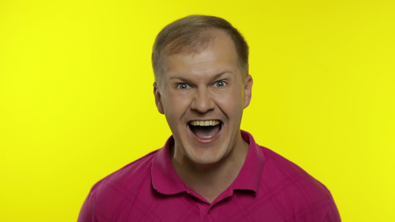 Portrait of young caucasian man posing in pink t-shirt. Satisfied handsome guy shouts, happy