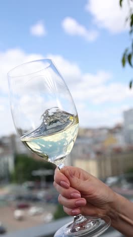 enjoying a glass of white wine with a city view