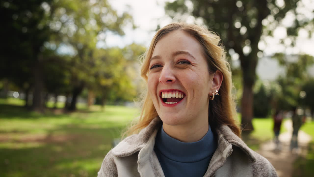 A laughing blond woman in a park