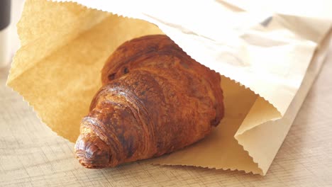 croissant in a paper bag
