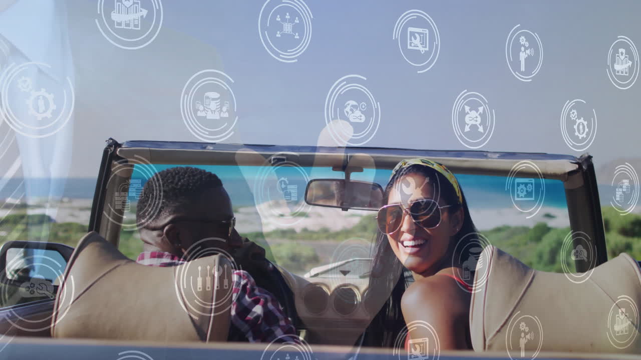 Riding in convertible, couple with digital animation overlay by scenic beach