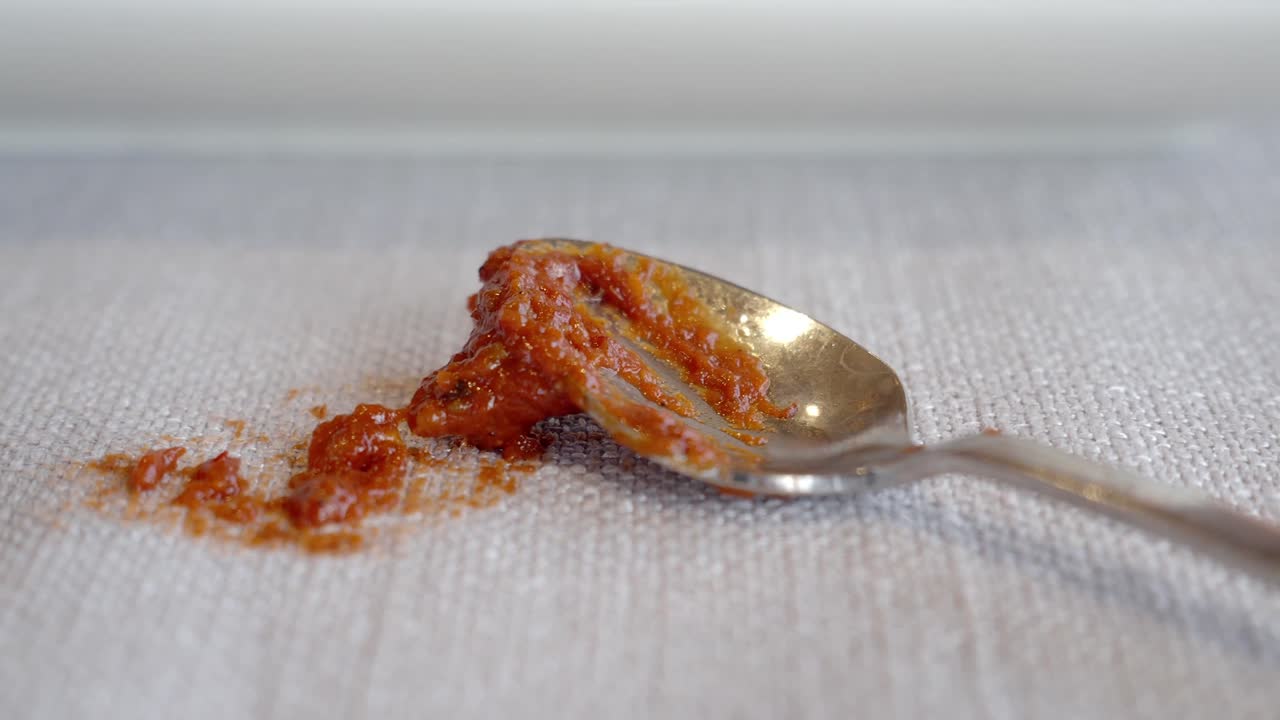 Spilled Reddish-Brown Sauce on a Spoon and Napkin