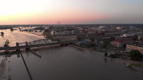 Sunset-aerial-cityscape-during-extreme-high-water-levels-of-river-IJssel-occupying-floodplains-of-Dutch-Hanseatic-medieval-tower-town-Zutphen-in-The-Netherlands