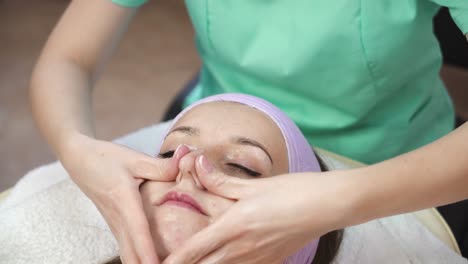 facial mask at spa salon. close up of young woman having facial mask in beauty parlor