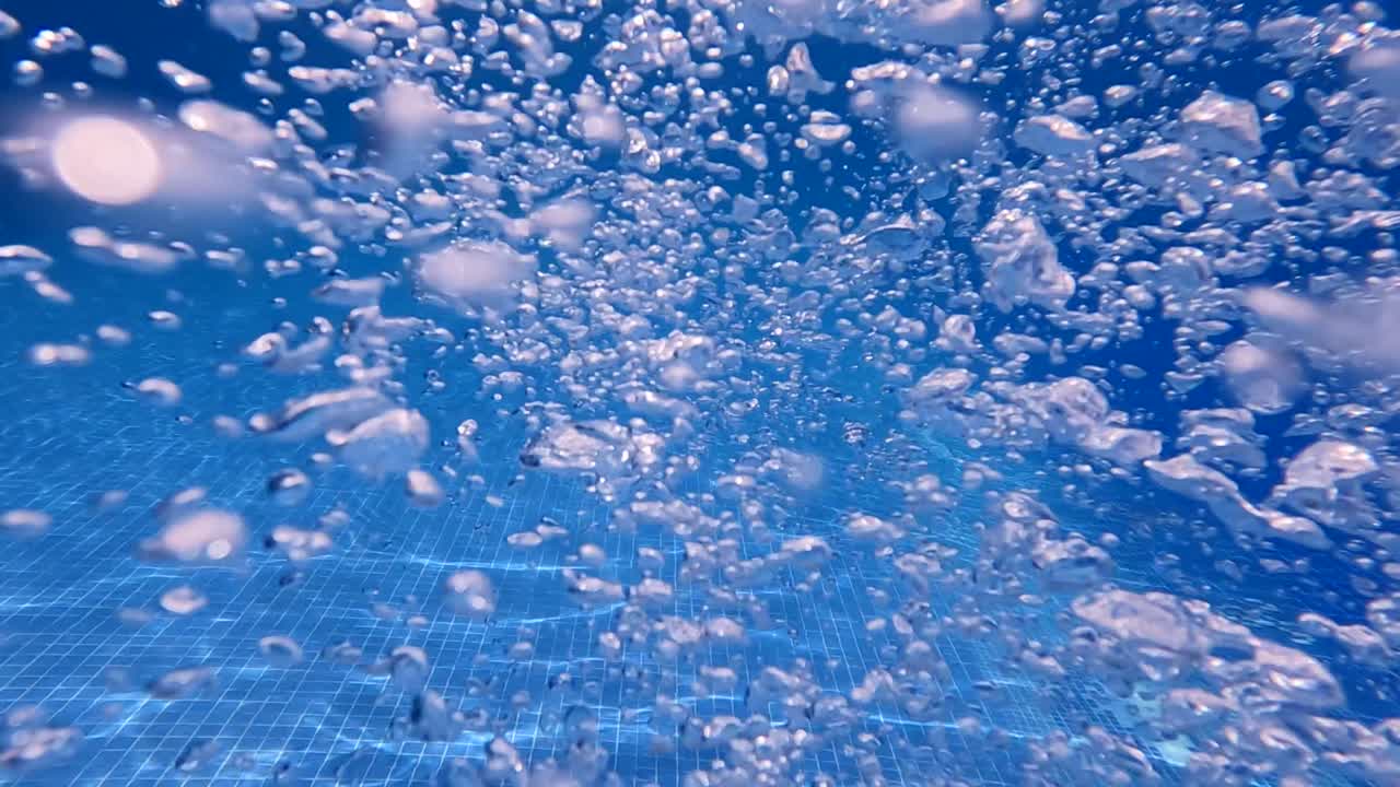 수영장에서 수영하는 동안 손과 물 거품을 움직입니다.