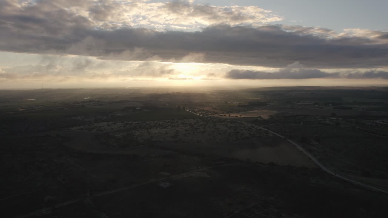 drones volando de lado sobre el hermoso paisaje italiano al amanecer con rayos de luz rompiendo las nubes en 4k