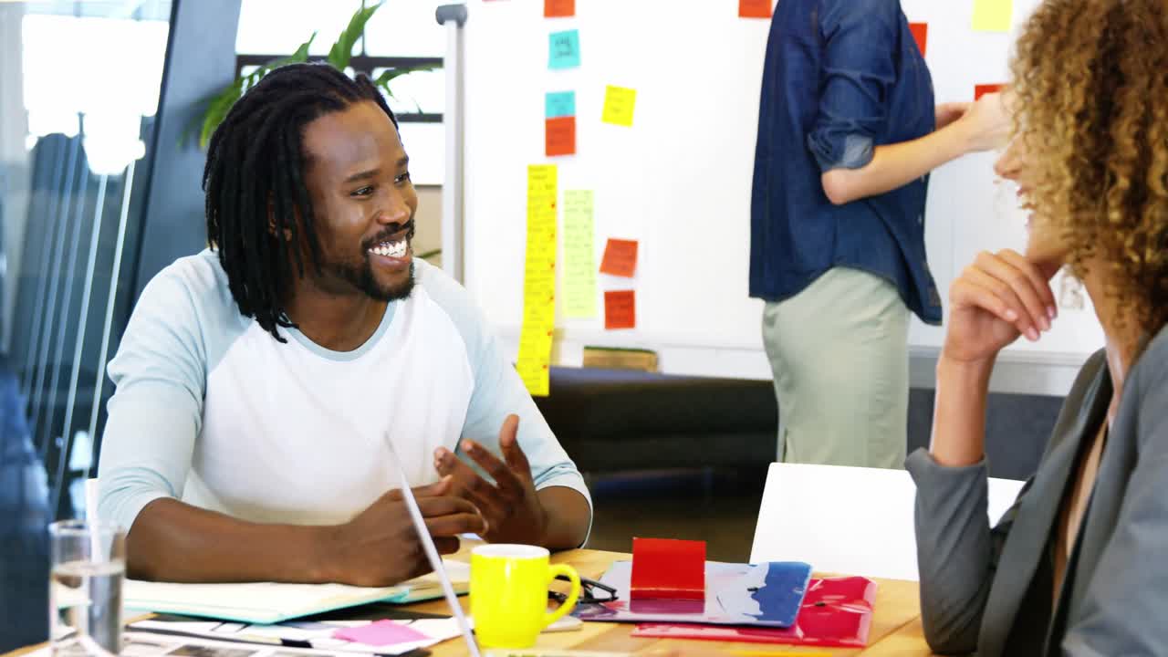 Happy colleagues having a discussion at desk