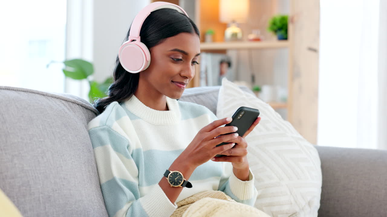 Donna che indossa cuffie e usa un telefono per