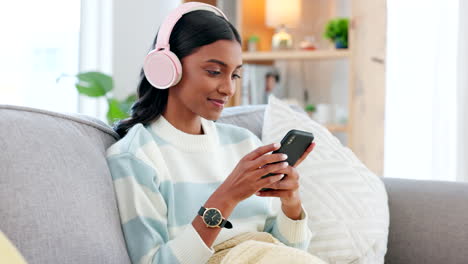 woman wearing headphones and using a phone to