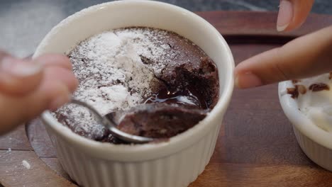 closeup of a chocolate lava cake with whipped cream and powdered sugar