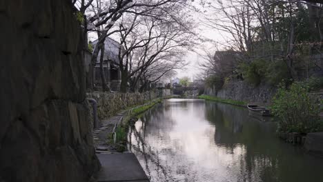 omihachiman moat in spring, sakura blooming over peaceful ancient waterway