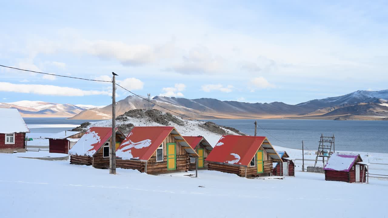 Rustic wooden cabins offer accommodation for tourists at a remote camp on the shores of Mongolia's Terkhiin Tsagaan Nuur (White Lake). A serene and isolated winter travel destination