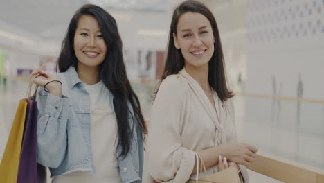 two happy women shopping in a mall