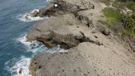 aerial view on rocky shoreline and ocean at punta las tunas and cueva del indio in puerto rico - drone shot